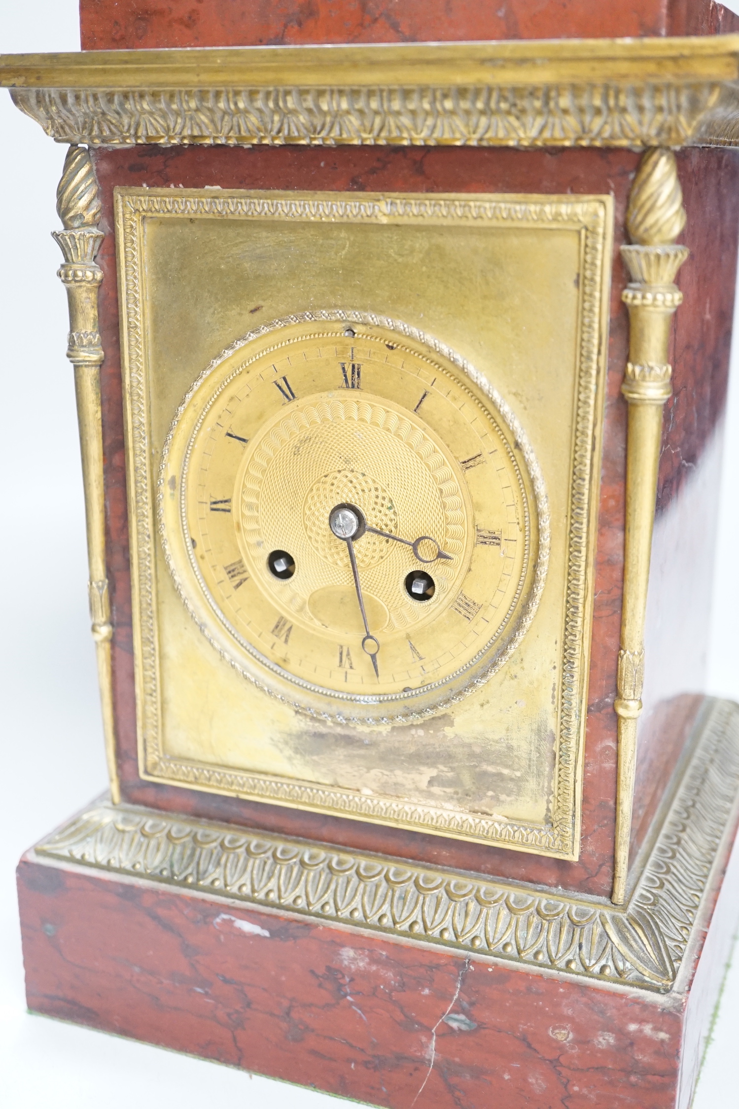 A French gilt metal mounted rouge marble mantel clock, first half 19th century, engine turned dial, 27cm high